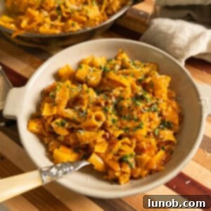 A vibrant bowl of Pasta and Potatoes, topped with fresh parsley and grated Parmesan cheese.