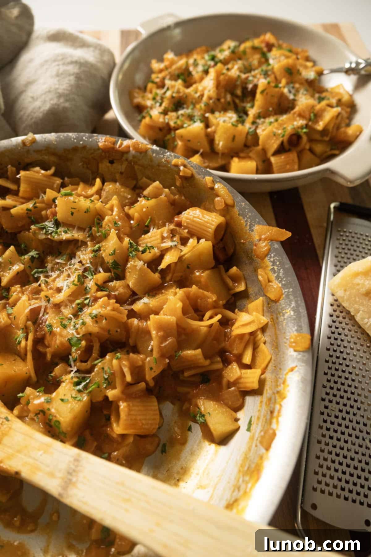 A beautifully plated serving of Pasta and Potatoes, garnished with fresh herbs and cheese.