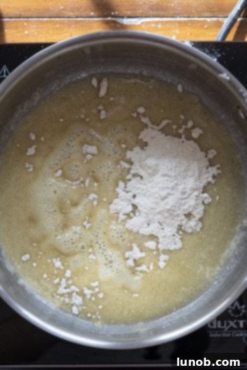 Italian Comfort Mac and Cheese 3 Close up of butter melting and flour being added into a saucepan