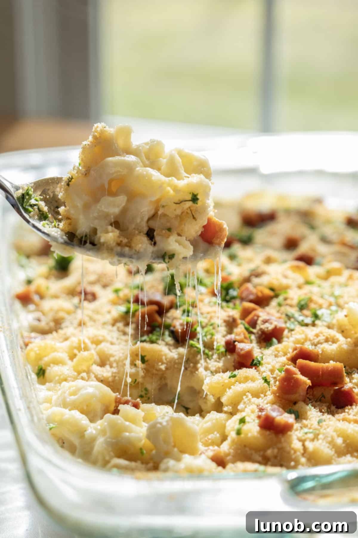Italian Comfort Mac and Cheese 9 A serving of Italian mac and cheese being lifted with a spoon, showing a dramatic cheese pull