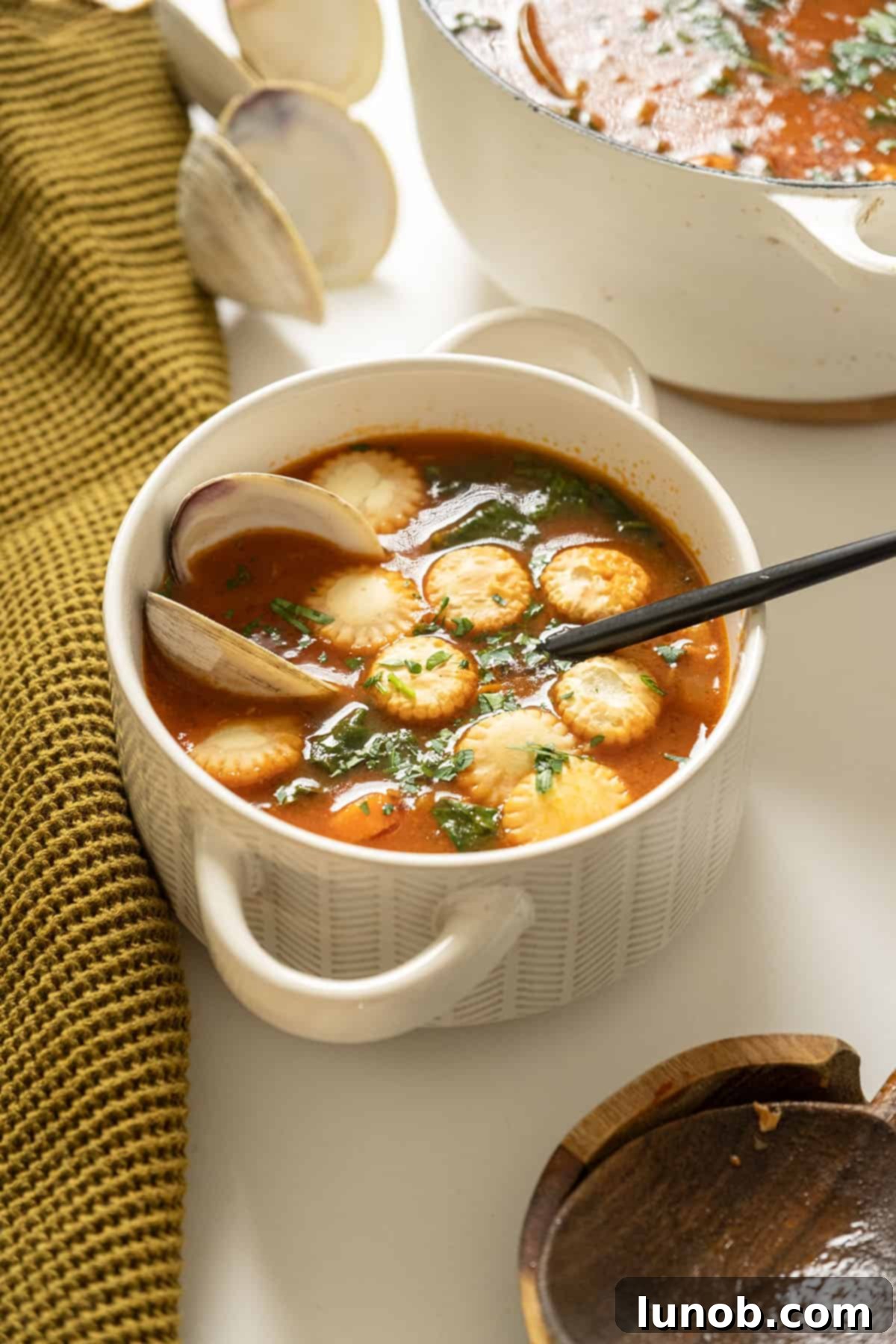 Manhattan clam chowder topped with oyster crackers in a bowl.