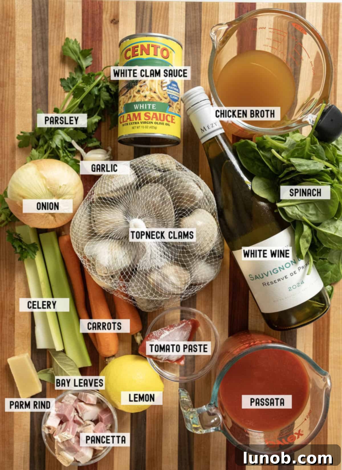 Ingredients for the Manhattan clam chowder recipe displayed on a wooden board.