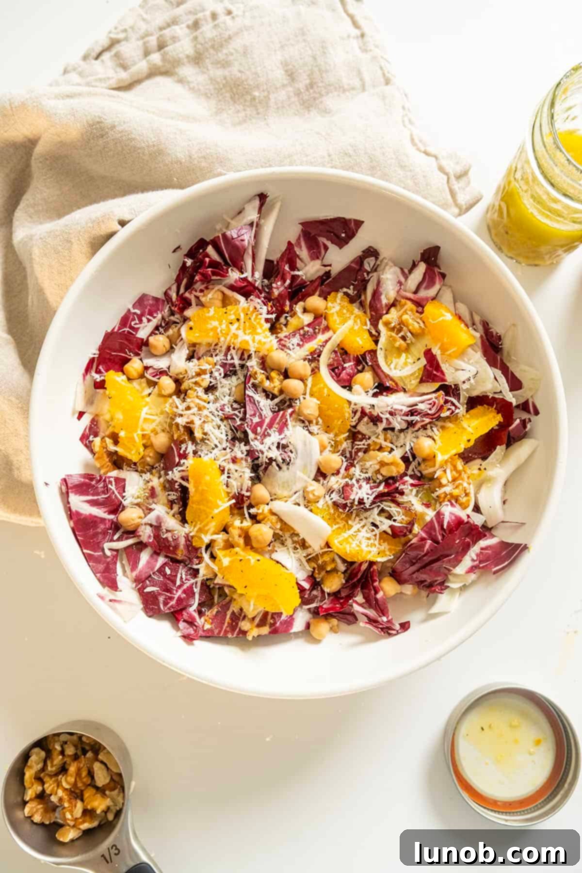 A beautifully composed Italian Radicchio Salad with chickpeas, fennel, oranges, and Parmesan in a rustic bowl.