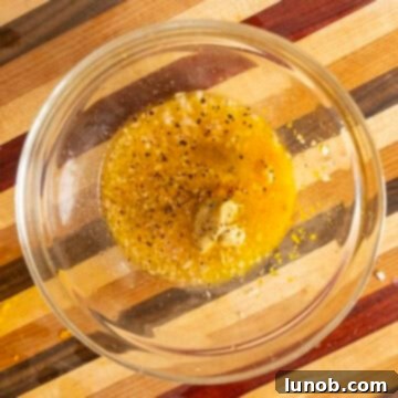 Combining various ingredients for the orange vinaigrette dressing in a bowl.