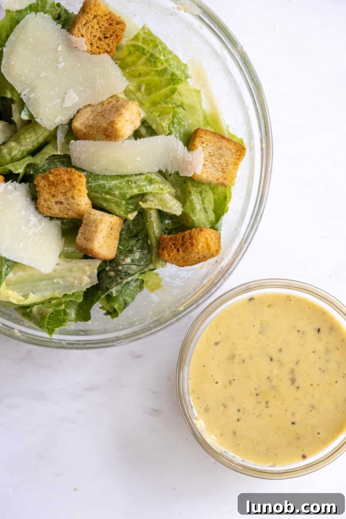 A vibrant, creamy traditional Caesar dressing, ready to be drizzled over a fresh salad.