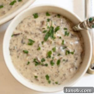 Creamy mushroom soup in a cup with a spoon.