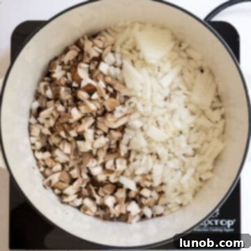 Mushrooms and onions sautéing in a dutch oven.