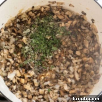 Sauteed mushrooms and onions with fresh herbs added and stirred.