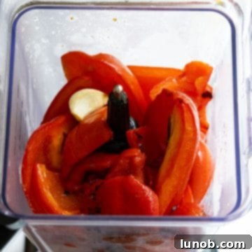 Roasted red peppers and garlic placed into a blender.
