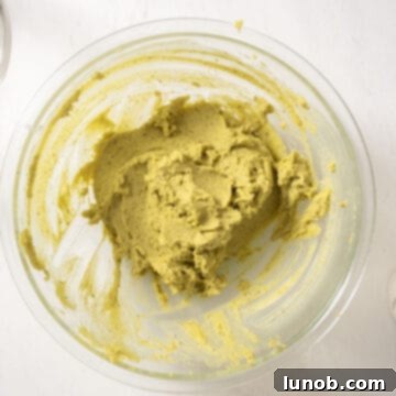 Pistachio butter, sugar, and mascarpone combined in a bowl, ready to be mixed.