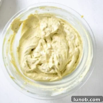 The stiff whipped cream being gently folded into the pistachio mascarpone and egg yolk mixture.