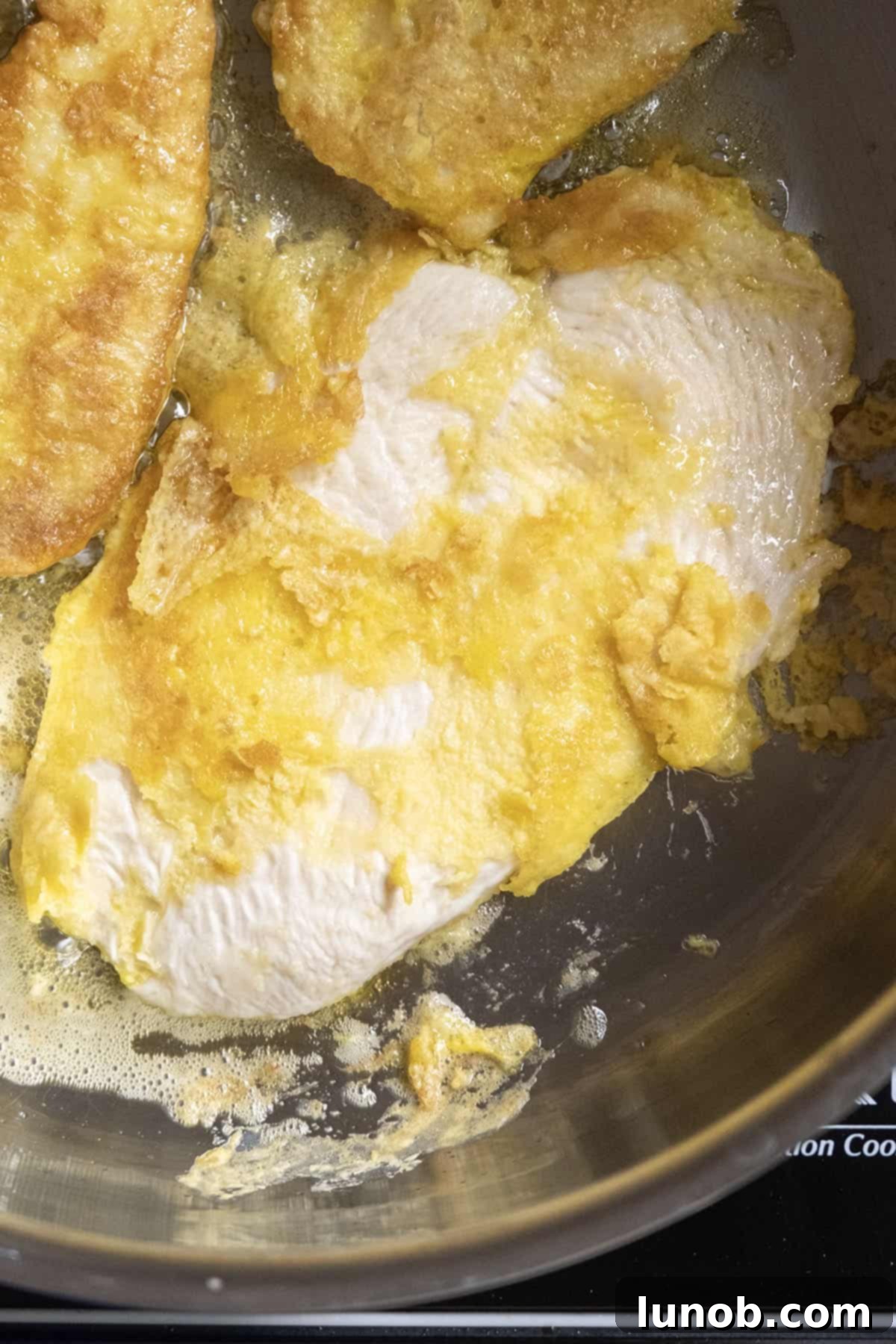 Gourmet Chicken Francese 8 An example of chicken fried with oil that was not hot enough, showing batter sticking to the pan and uneven cooking.