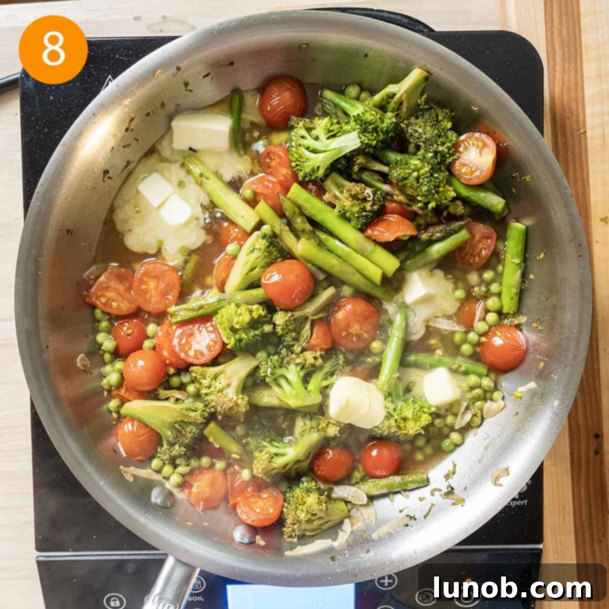 Stirring butter into the simmering sauce in a pan.