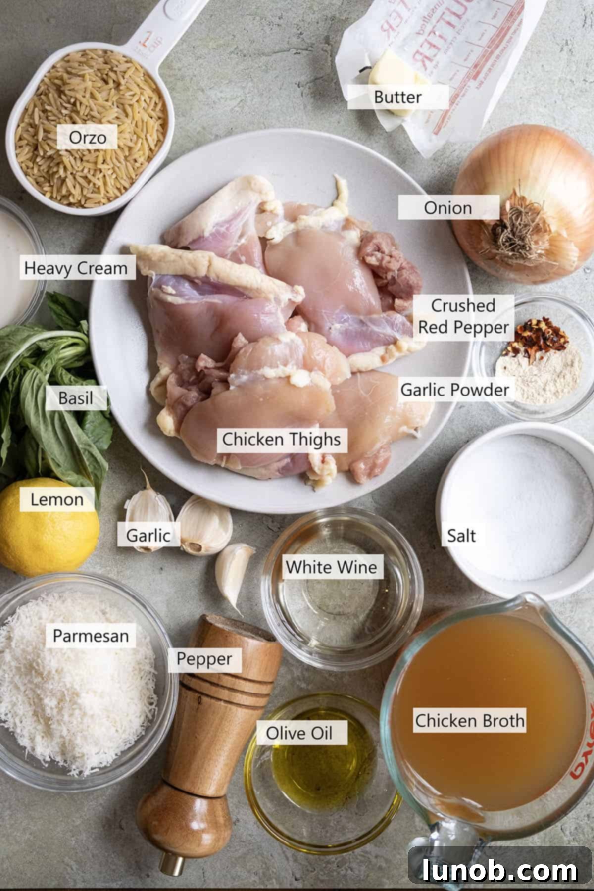 One-Pan Lemon Chicken Orzo Skillet 3 Fresh ingredients laid out for a creamy lemon chicken orzo recipe, including chicken, lemon, fresh basil, and garlic.