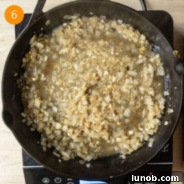 One-Pan Lemon Chicken Orzo Skillet 6 Simmering onions and garlic with white wine in a cast iron pan, deglazing the fond.