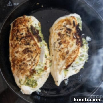 Irresistible Pesto Stuffed Chicken 8 Stuffed chicken breast searing beautifully in a hot cast iron skillet.