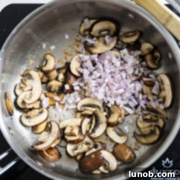 Gourmet Chicken Marsala 7 Frying mushrooms in the pan that are slightly browned with fresh chopped shallots just added.