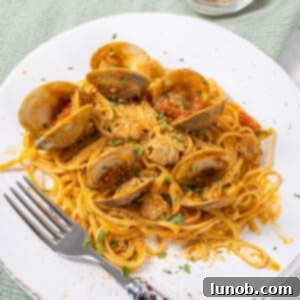linguine with clams in red sauce on a plate.
