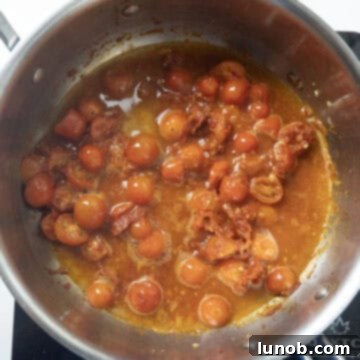 White wine being poured into the simmering tomato sauce.