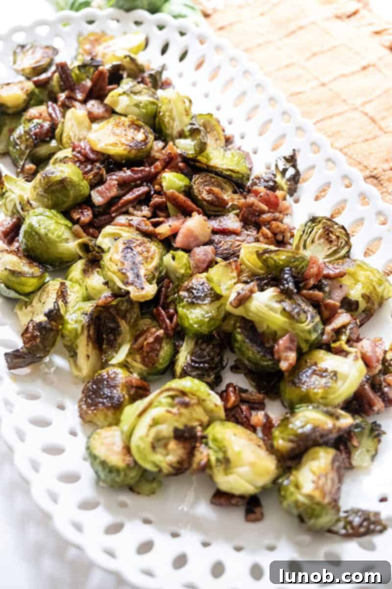 Honey Glazed Prosciutto Asparagus 2 Crispy roasted Brussels sprouts with glistening maple syrup, savory bacon bits, and crunchy pecans on a serving plate.