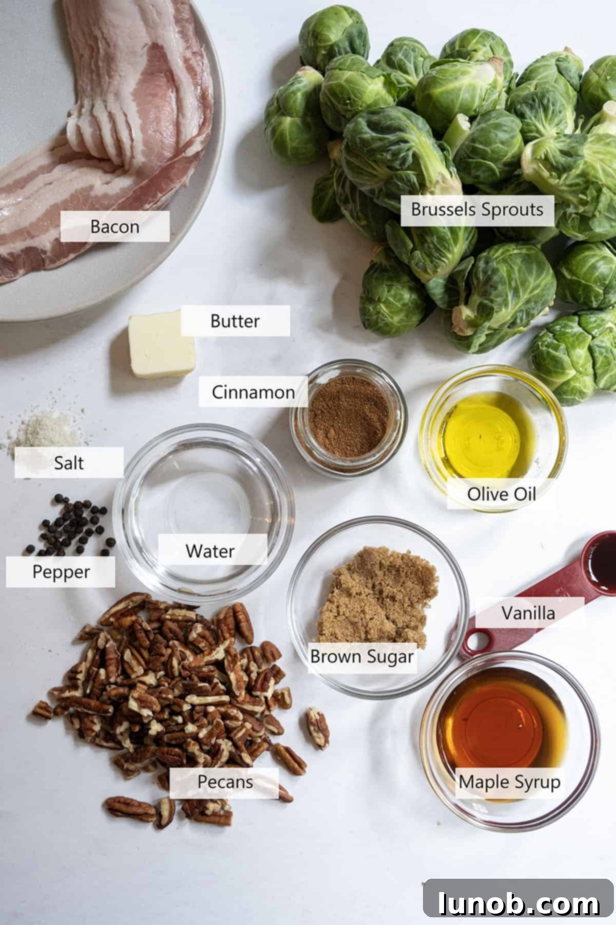 Honey Glazed Prosciutto Asparagus 3 Fresh Brussels sprouts, thick-cut bacon, olive oil, real maple syrup, and whole pecans laid out as ingredients for the recipe.