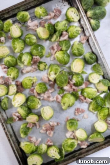 Honey Glazed Prosciutto Asparagus 4 Chopped bacon and halved Brussels sprouts evenly spread on a baking tray, ready for roasting.