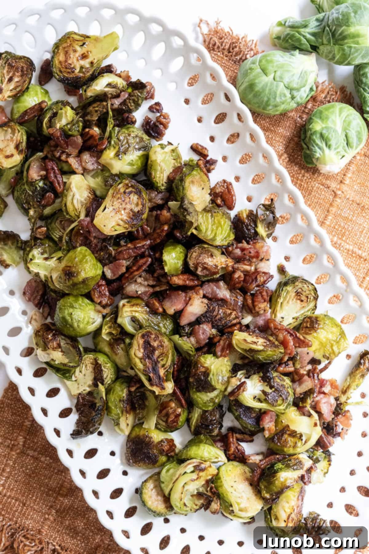 Honey Glazed Prosciutto Asparagus 10 A close-up of a serving of Maple Bacon Brussels Sprouts, showcasing the crispy bacon, glazed pecans, and perfectly roasted green sprouts.