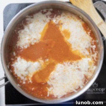 Ultimate Chicken Pizzaiola 11 Chicken cutlets generously topped with shredded low-moisture mozzarella cheese, preparing for a perfect melt.