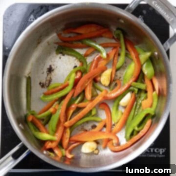Ultimate Chicken Pizzaiola 7 Colorful bell peppers and whole garlic cloves sautéing in the same pan, infusing flavor into the oil.
