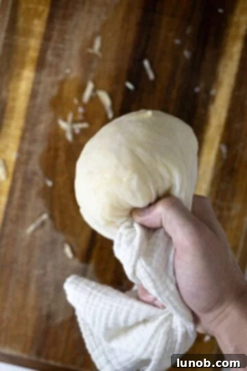 Drying grated potatoes with a cheese cloth.