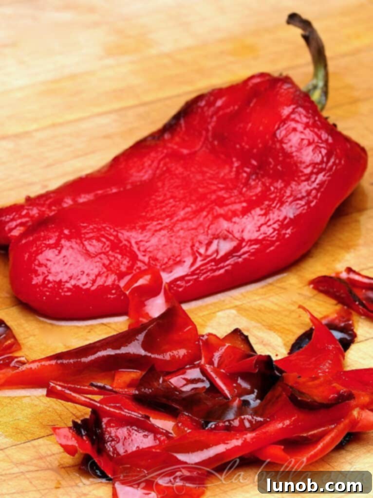 Perfectly Roasted Red Peppers: Freeze for Future Flavor 8 Close-up of roasted red pepper halves, with some skin peeled away, demonstrating the texture