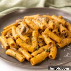 Velvety Garlic Mushroom Pasta 12 Creamy mushroom pasta on a plate garnished with parmesan.