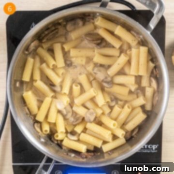 Velvety Garlic Mushroom Pasta 9 Pasta added to sauce in the pan.