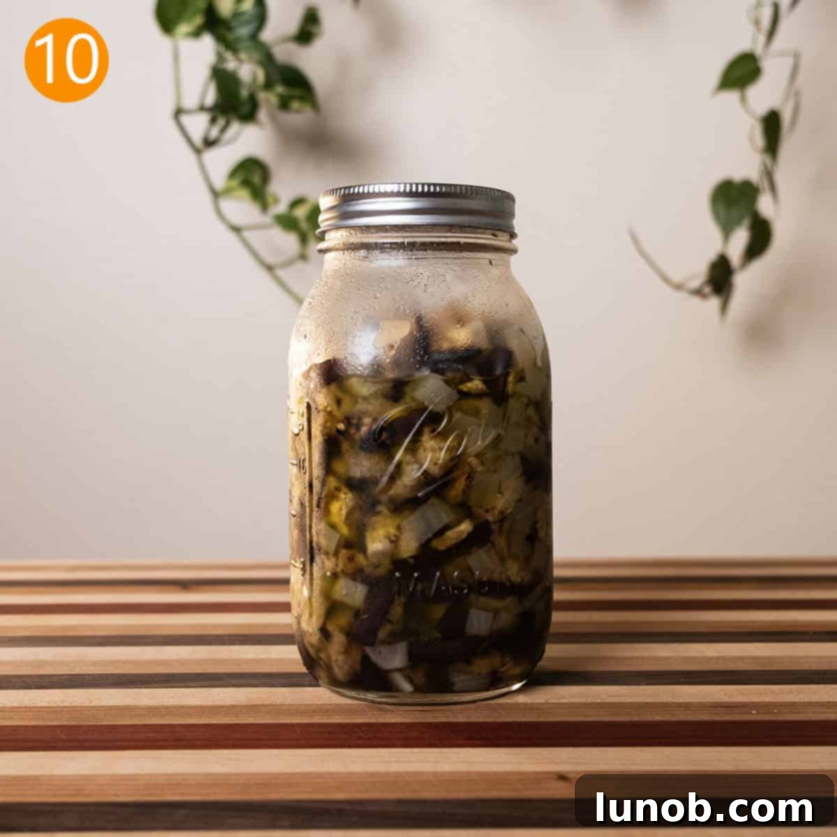 Tangy Marinated Eggplant and Onion 8 Marinated eggplant and onion mixture stored in a clear mason jar, ready for refrigeration and infusion of flavors.