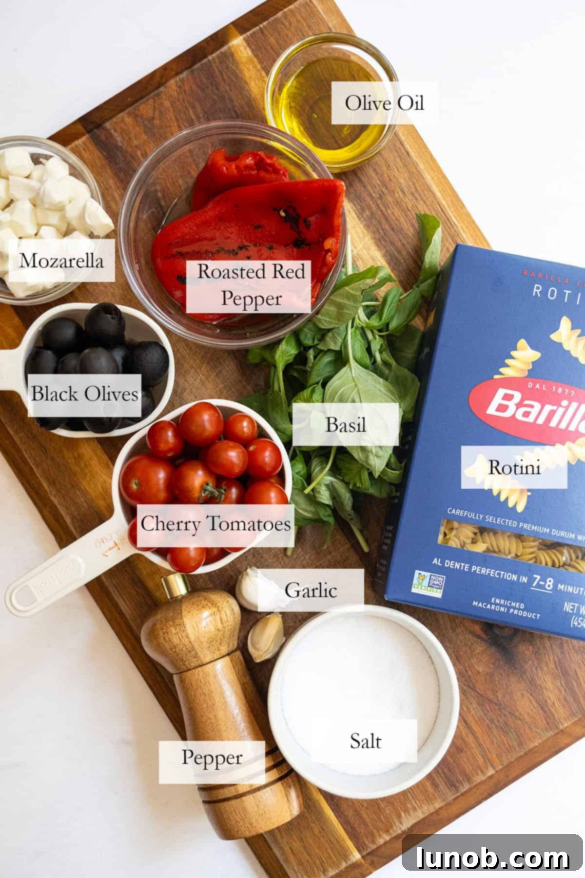 ingredients for the pasta salad on a cutting board.