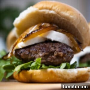 A close-up of a goat cheese and fig jam slider, perfectly assembled on a cutting board, showcasing its gourmet appeal.