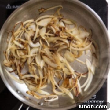 Caramelized onions, deeply golden brown and soft, finished cooking in the frying pan.