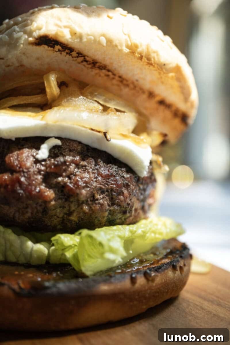 A perfectly assembled goat cheese and fig jam slider on a cutting board, ready to be served, showcasing the layers of flavor.
