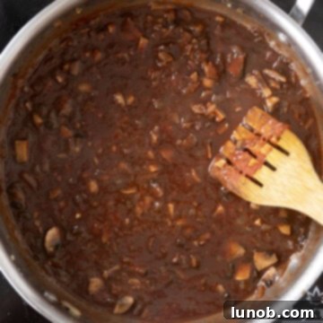 Red wine and chicken broth added to the caramelized tomato paste and vegetables, ready for deglazing.