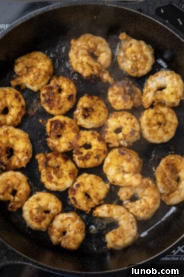 seared shrimp cooking in a cast iron skillet, showing a beautiful char