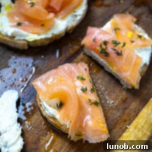 Lox on top of mascarpone toast on a cutting board with an old school butter knife covered in mascarpone.