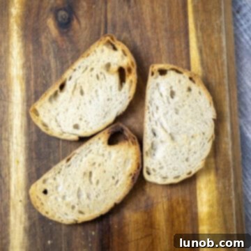 Perfectly toasted bread on a rustic cutting board, ready for toppings.
