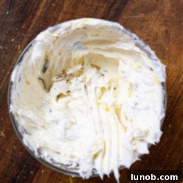 Mascarpone cheese blended with fresh thyme, lemon zest, salt, and pepper in a bowl.