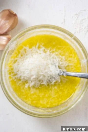 A small bowl containing freshly grated Pecorino Romano cheese mixed with bright yellow lemon zest, ready to be combined with lemon juice for the pasta sauce.