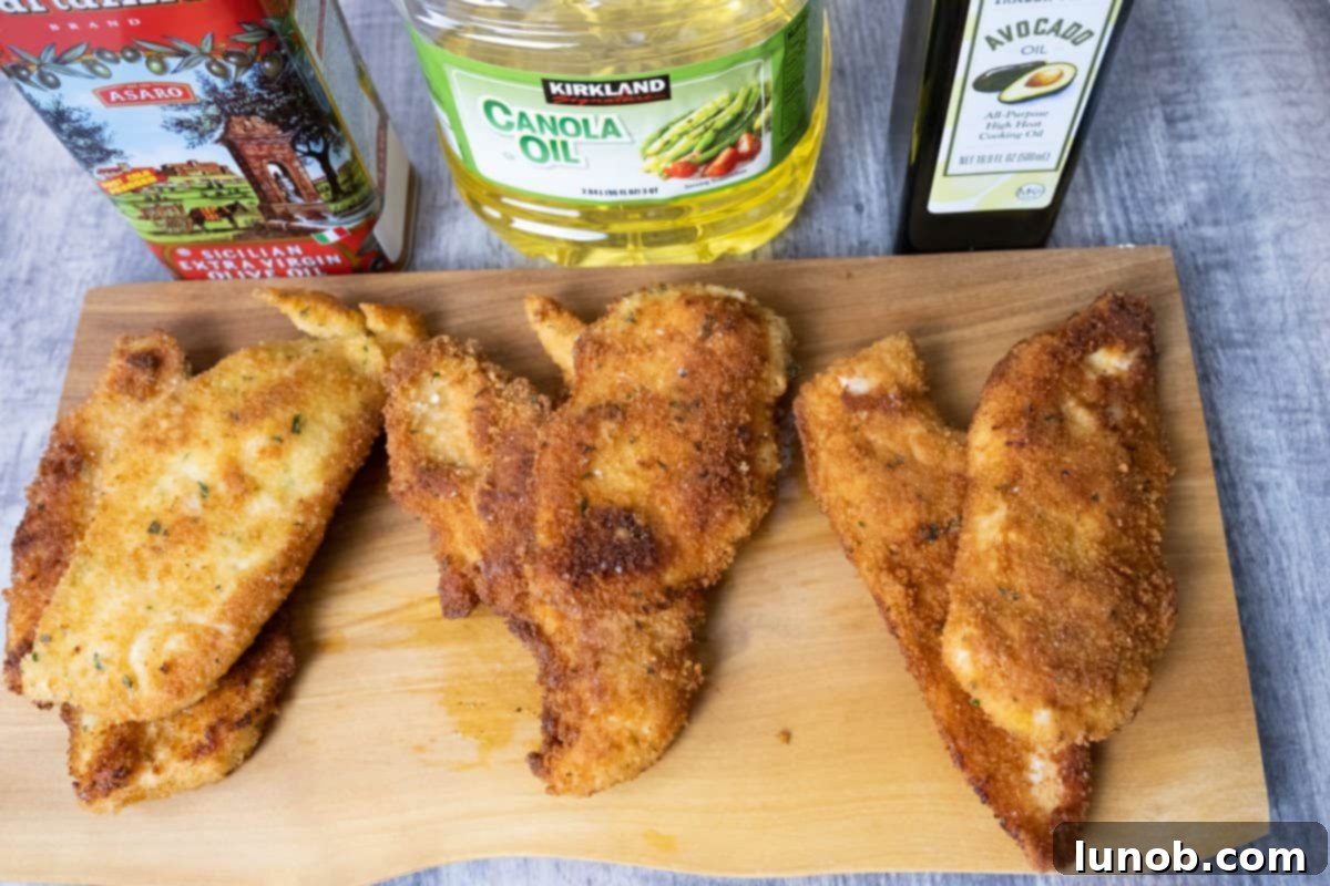 Golden Cutlets The Right Oil for Frying 13 Three perfectly fried chicken cutlets, showcasing the varying golden hues and textures achieved with different oils.