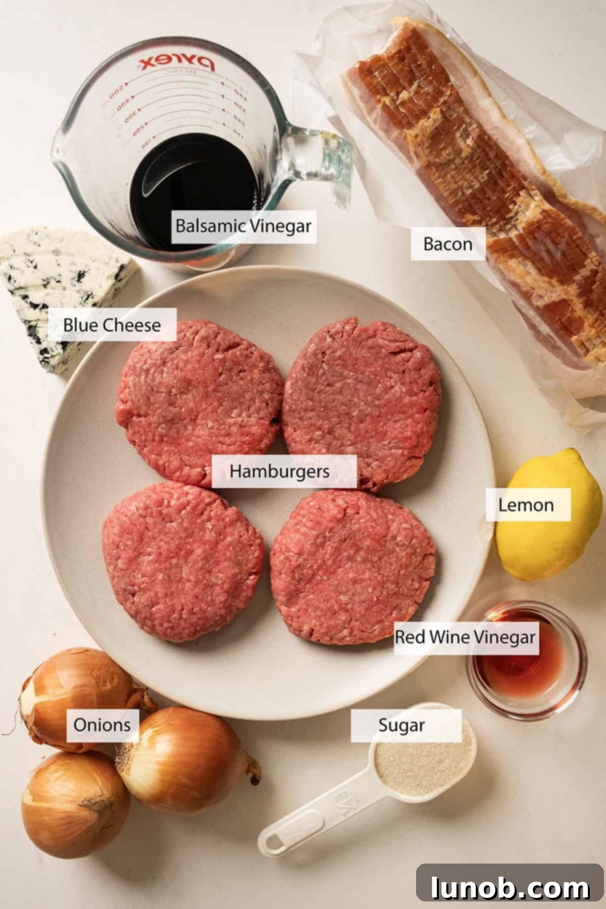 Bacon Blue Cheese Burger 3 Fresh ingredients laid out for making the Bacon Blue Cheese Burger recipe, including onions, bacon, blue cheese, and ground beef.