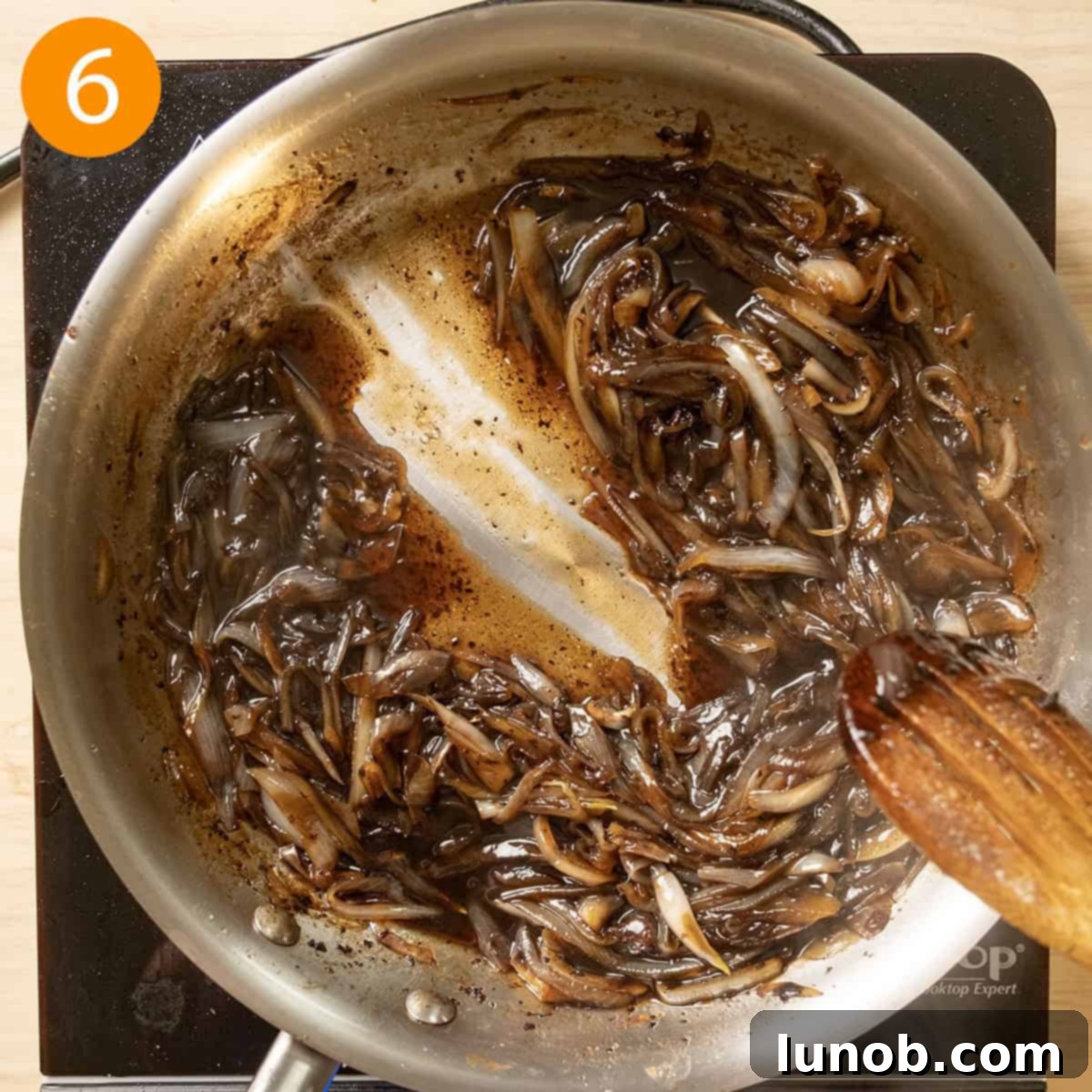 Bacon Blue Cheese Burger 7 Finished caramelized onion jam in a pan, thick and glossy, with a spoon dragged through to demonstrate its rich, jammy consistency.