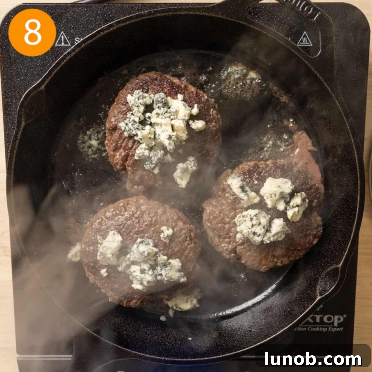 Bacon Blue Cheese Burger 9 Grilled burger patties with blue cheese crumbles melting on top, indicating they are almost ready.