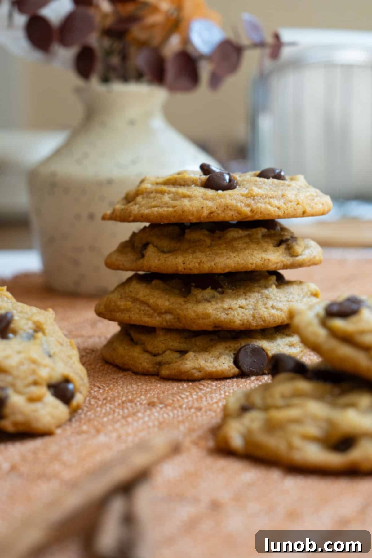 Irresistible Chewy Pumpkin Chocolate Chip Cookies 2 A stack of perfectly baked, chewy pumpkin chocolate chip cookies, garnished with flaky sea salt.