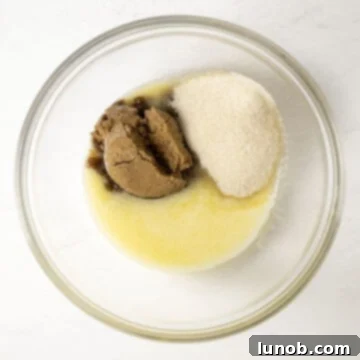 Irresistible Chewy Pumpkin Chocolate Chip Cookies 5 A bowl with melted butter, granulated sugar, and brown sugar mixed together, ready for the next step.